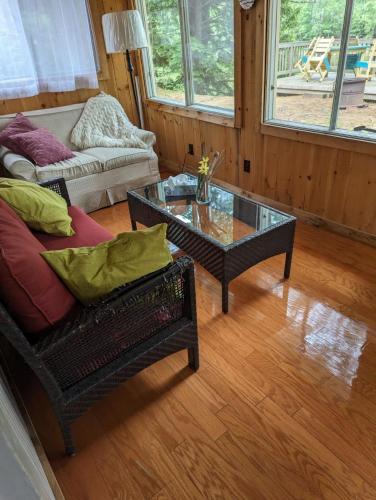 a living room with a couch and a glass table at Riverfront Rustic Cottage in Durham Bridge