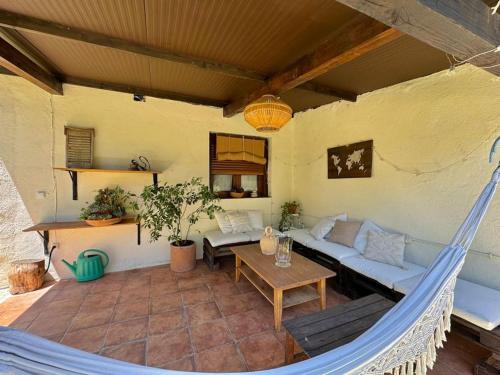 a hammock in a living room with a couch and a table at Casita Rural de Campo con Jardín Privado in El Berrueco