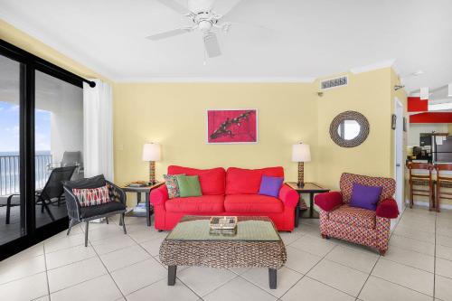 a living room with a red couch and chairs at Windward Pointe 1401-Large balcony best views in Orange Beach