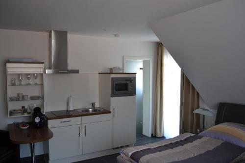a white kitchen with a sink and a counter at Campus Boardinghouse in Aachen
