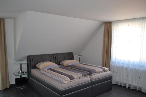 a bed sitting in a room with a window at Campus Boardinghouse in Aachen