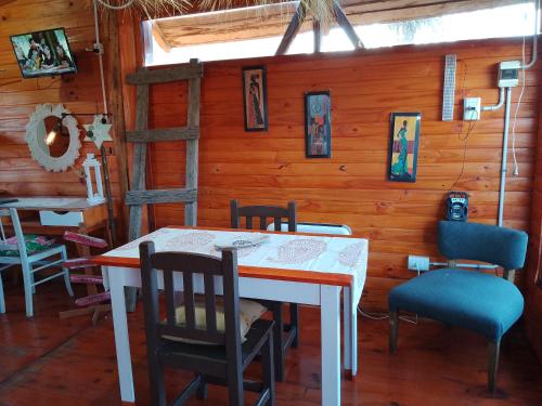 a dining room with a table and chairs and a ladder at FINCA los nogales in General Belgrano