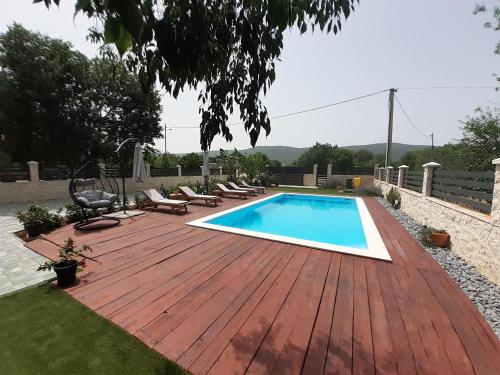a wooden deck with a swimming pool on a backyard at Apartment Karla SNB in Lozovac