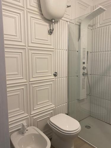 Un baño blanco con inodoro y ducha. en B&B Villa La Petra, en San Nicola Arcella