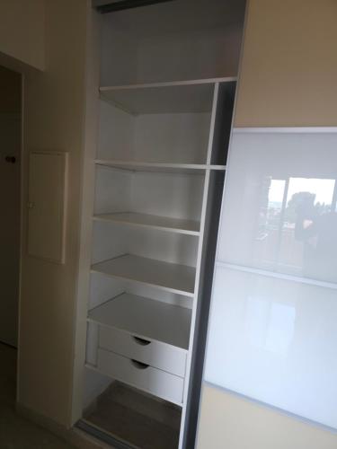 Cette chambre comprend un placard avec des étagères blanches. dans l'établissement Maryland Antibes standing 45m2 au calme proche plage et centre-ville - Parking privé - Wifi, à Antibes