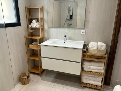 une salle de bain avec un lavabo, un miroir et des serviettes dans l'établissement Casa sole e mare, à Conca