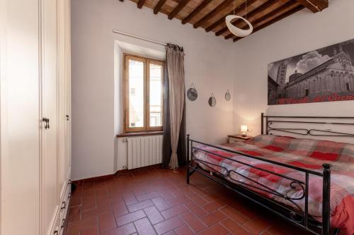 a bedroom with a bed and a window at Residenza il Vicolo del Corso in Massa Marittima