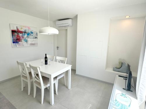 una sala da pranzo bianca con tavolo e sedie bianchi di ArtApArt T a Rabac