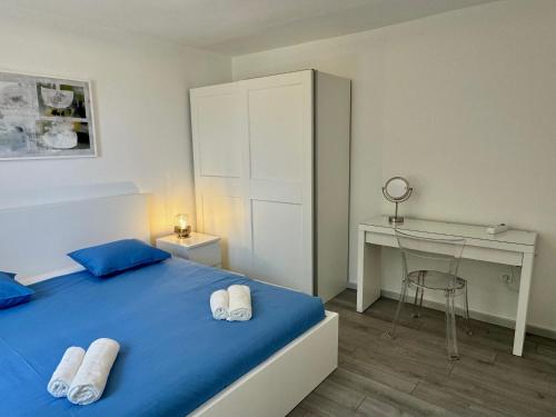 una camera da letto con un letto blu e una scrivania di ArtApArt T a Rabac