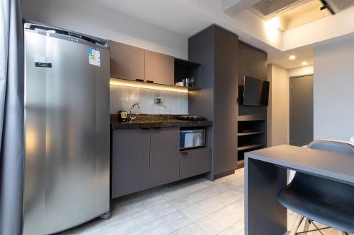 a kitchen with a stainless steel refrigerator and a table at TOLIVE One Housi Recife by Carpediem in Recife