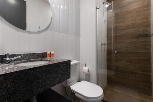 a bathroom with a toilet and a sink and a shower at TOLIVE One Housi Recife by Carpediem in Recife