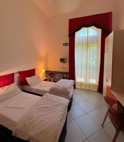 a hotel room with two beds and a window at Auberge de la Gare - Dortoir & Ostello in Hone