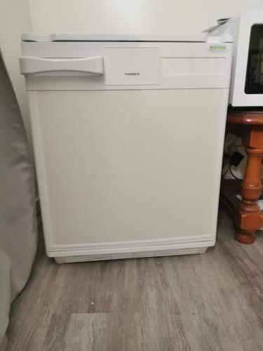 un lave-vaisselle blanc posé dans une cuisine à côté d'une table dans l'établissement Logis ST Cyrien, à Saint-Cyr-en-Val