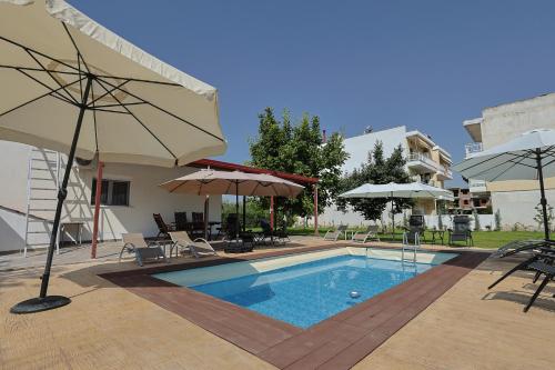 a large swimming pool with umbrellas and chairs at Zeusplace Alexandra's Pool Villa Katerini in Katerini