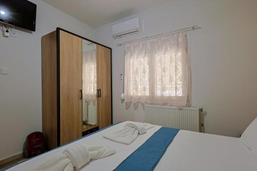 a bedroom with a bed and a mirror and a window at Zeusplace Alexandra's Pool Villa Katerini in Katerini