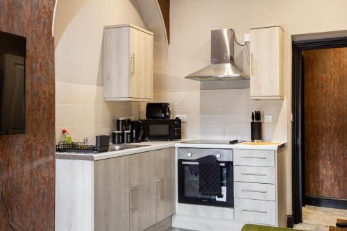 a kitchen with a stove and a microwave at Crown Street Aparthotel 2 in Halifax