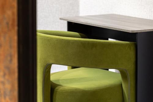 a table and two green chairs next to a table at Crown Street Aparthotel 2 in Halifax