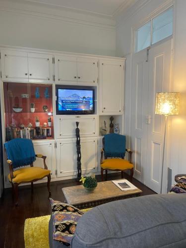 a living room with a couch and a tv at Patio da Foz - Appartement très accueillant centre-ville in Figueira da Foz