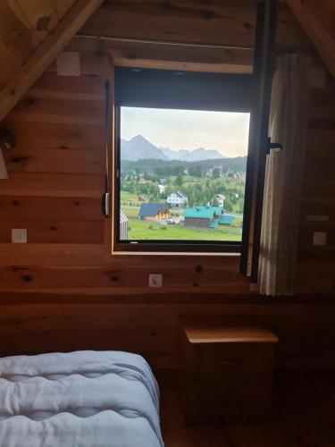 une chambre avec une fenêtre donnant sur une ferme dans l'établissement Holiday home Mountain, à Žabljak