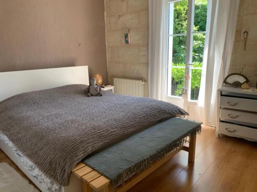 - un ours en peluche assis sur un lit dans une chambre dans l'établissement villa dans l entre deux mers secteur saint Emilion sauternes, à Verdelais