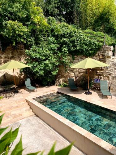- une piscine avec 2 parasols, des chaises et une table dans l'établissement villa dans l entre deux mers secteur saint Emilion sauternes, à Verdelais
