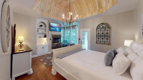 - une chambre avec un grand lit blanc et un lustre dans l'établissement Cozy 5BR Escape: Games Room, Grill, Near Hiking, à Marietta