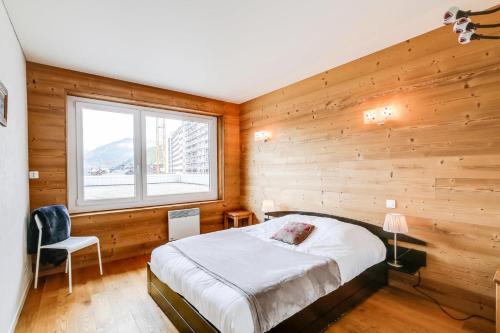 - une chambre avec des murs en bois, un lit et une fenêtre dans l'établissement Résidence Le Bec Rouge - Appartement de charme 3 pièces 8 personnes à Tignes au pied des pistes et proche des commerces dans le quartier du Lac. Vue impr MAE-1681, à Tignes