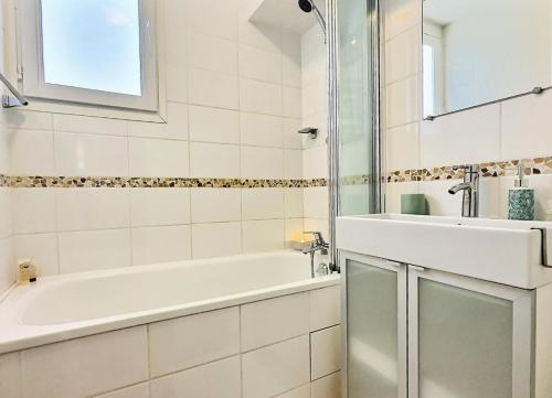 une salle de bain blanche avec une baignoire et un lavabo dans l'établissement Résidence Le Lac - 3 Pièces pour 8 Personnes 82, à Tignes