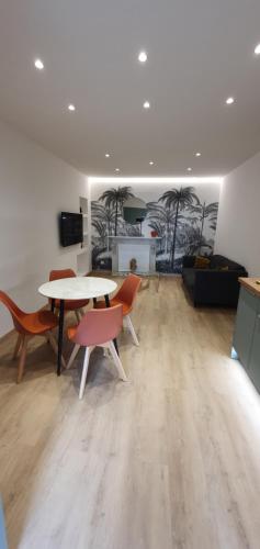 - un salon avec des tables, des chaises et des palmiers dans l'établissement Casa di missia, à Sartène