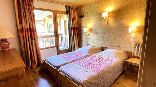 une chambre avec un lit dans une pièce en bois dans l'établissement Résidence Les Cytelles - Appartement 2 pièces rénové, 5 personnes à Meribel Altiport au pied des pistes et proche du golf MAE-1751, à Les Allues