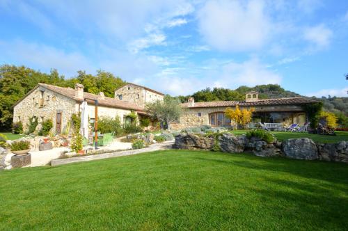 a house with a yard with a stone wall at Luxury villa Colle dell'Asinello ,proprietari ,Villa In esclusiva near ORVIETO in Guardea