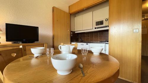 - une cuisine avec une table en bois avec des bols et des verres dans l'établissement Résidence Les Cytelles - Studio pour 4 personnes à Meribel Altiport, au pied des pistes et proche du golf MAE-1779, à Les Allues