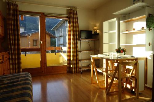 un salon avec une table et une cuisine avec une fenêtre dans l'établissement Résidence Jardins Du Nantet - Studio 4 personnes à Bourg Saint Maurice proche centre ville et des commerces MAE-1809, à Bourg-Saint-Maurice