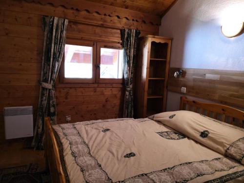 une chambre avec un lit dans une cabane en bois dans l'établissement Résidence Fermes De Meribel G - Agréable appartement 3 pièces 6 personnes à Méribel Village proche des pistes et des commerces de Méribel Village MAE-1882, à Les Allues