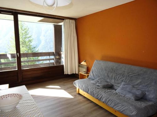 un salon avec un canapé et une grande fenêtre dans l'établissement Résidence Rey - Plan Peisey - Appartement 2 pièces 6 personnes à Plan Peisey proche des commerces et des pistes MAE-1885, à Peisey-Nancroix