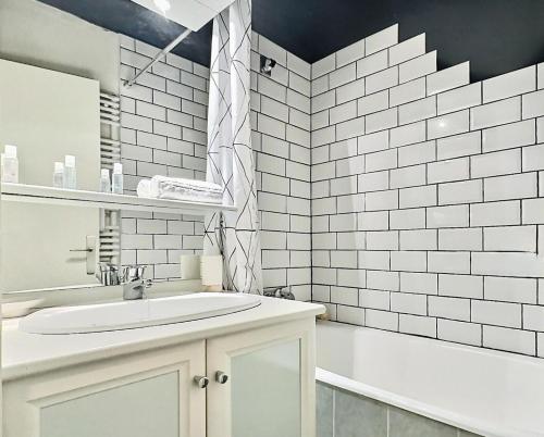 La salle de bains blanche est pourvue d'un lavabo et d'une baignoire. dans l'établissement Résidence Lot 300 A Et B - Appartement 2 pièces 4 personnes proche des pistes et des commerces dans le quartier du Lavachet. Situé au 4ème étage d'une rési MAE-1926, à Tignes