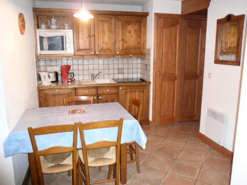 une cuisine avec une table et des chaises dans une cuisine dans l'établissement Résidence Bergerie Des 3 Vallees D - Joli appartement 3 pièces 4 personnes situé sur Les Allues dans un quartier calme MAE-1971, à Les Allues