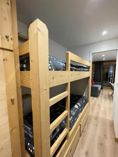 Cette chambre dispose de lits superposés en bois et de bouteilles de vin. dans l'établissement Résidence Le Lac Blanc - Studio 4 personnes à MOTTARET au pied des pistes et des commerces MAE-1985, à Les Allues