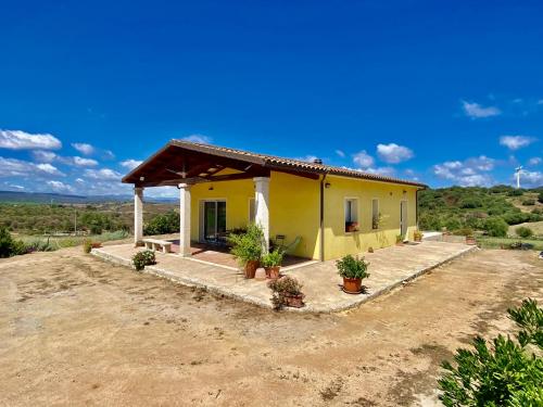 a small yellow house with plants in front of it at San Leonardo Country House in Calangianus