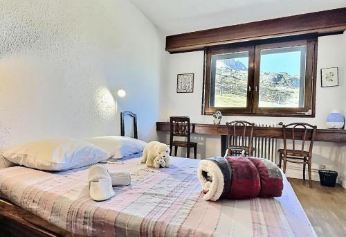 a bedroom with two dogs laying on a bed at Résidence Les Ducs De Savoie - Appartement 2 pièces 6 personnes à Tignes au pied des commerces, du bowling et proche des pistes, de la piscine et de l'office d MAE-2010 in Tignes
