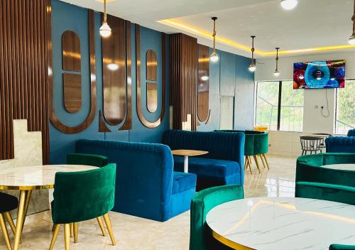 a waiting room with blue chairs and tables at Kam Apartment and Taverns in Abuja