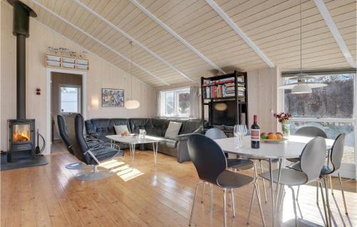 Una sala de estar con mesa y sillas y una chimenea. en Gorgeous Home In Græsted With Sauna, en Græsted