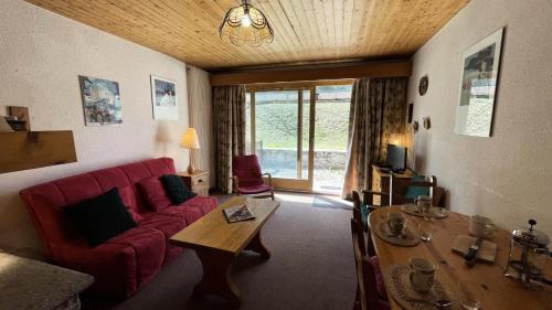 un salon avec un canapé rouge et une table dans l'établissement Résidence Chasseforet - Appartement 2 pièces 4 personnes situé à Méribel sur la route des Chalets proche des pistes MAE-2107, à Les Allues