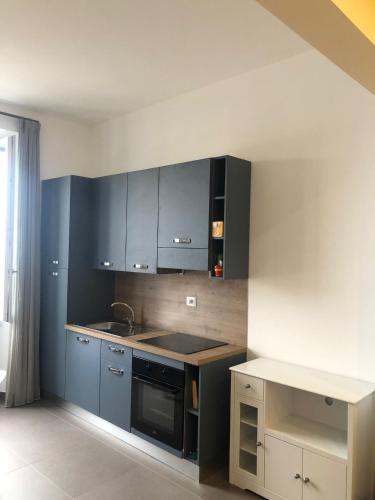 a kitchen with blue cabinets and a stove top oven at La Maison sul Porto in Anzio
