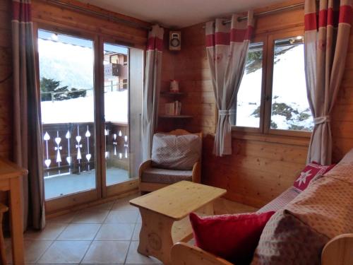 a living room with a couch and a table and windows at Résidence Bergerie Des 3 Vallees D - Joli appartement 3 pièces 4 personnes situé sur Les Allues dans un quartier calme MAE-2122 in Les Allues