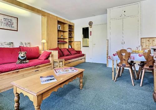 un salon avec un canapé rouge et une table dans l'établissement Résidence Le Bec Rouge - Studio 4 personnes à Tignes ski aux pieds et proche des commerces dans le quartier du Lac. Vue imprenable sur le Lac. MAE-2118, à Tignes
