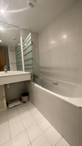 une salle de bain avec une baignoire, un lavabo et un miroir dans l'établissement Résidence Le Cristal - Appartement 2 pièces 4 personnes situé à Méribel centre avec piscine extérieure et proche des commerces MAE-2134, à Les Allues