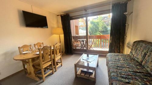 un salon avec une table et un canapé et une salle à manger dans l'établissement Résidence Le Cristal - Appartement 2 pièces 4 personnes situé à Méribel centre avec piscine extérieure et proche des commerces MAE-2134, à Les Allues