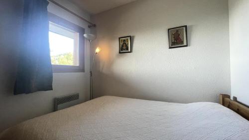 une chambre avec un lit blanc et une fenêtre dans l'établissement Résidence Le Cristal - Appartement 2 pièces 4 personnes situé à Méribel centre avec piscine extérieure et proche des commerces MAE-2134, à Les Allues