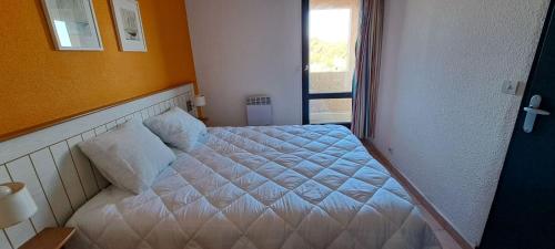 un lit dans une chambre avec une fenêtre dans l'établissement Résidence Odalys Cap d'Agde - Piscine chauffée, clim, plage, parking privé, terrasse, au Cap d'Agde